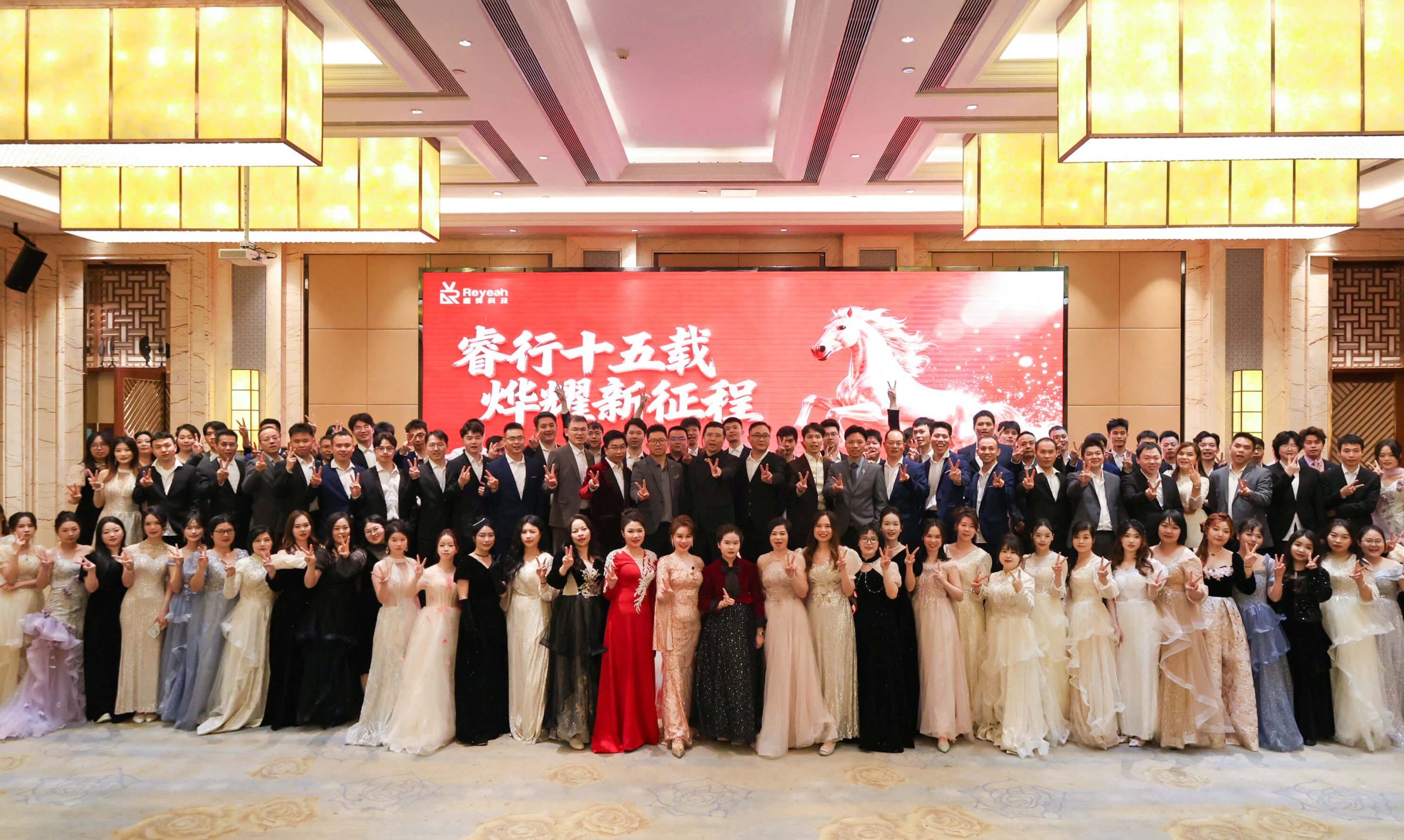 Large group photo of the 130+ PhoPrint staff at their annual dinner, decorated with Spring Festival and 15th-anniversary themes.